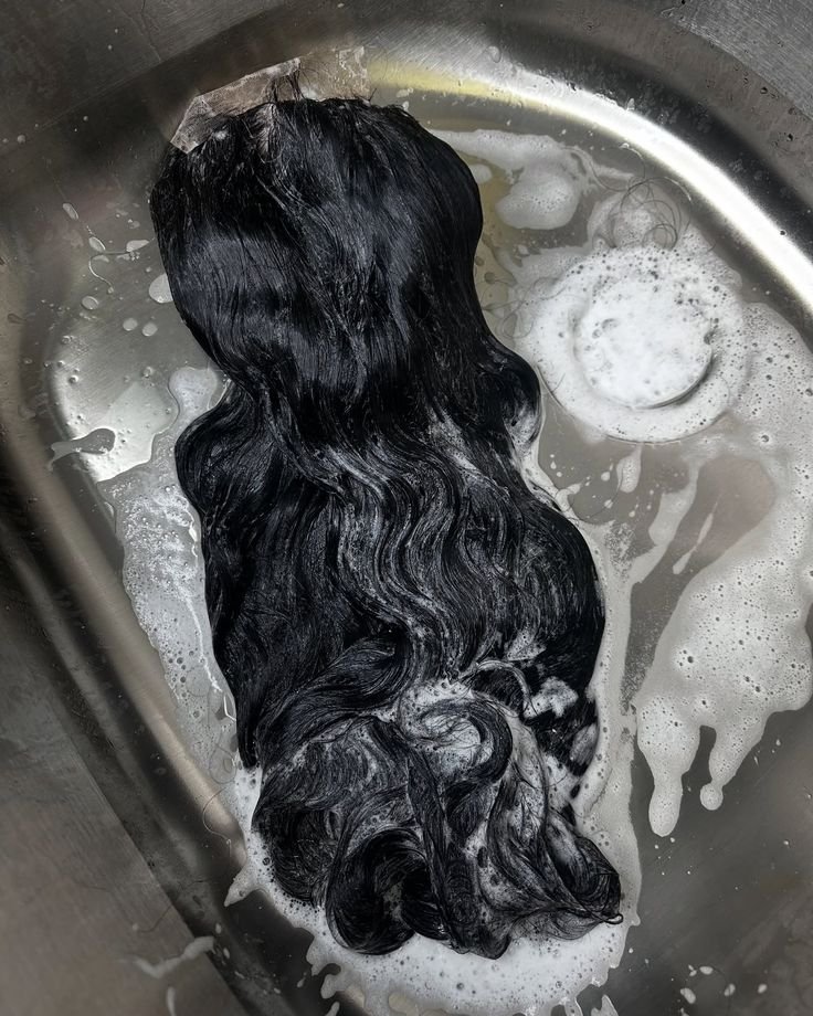 Femme noire lavant une perruque pendant sa routine beauté